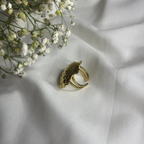 Gold ring on a white fabric background with small white flowers
