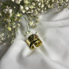 Gold ring on a white fabric background with small white flowers